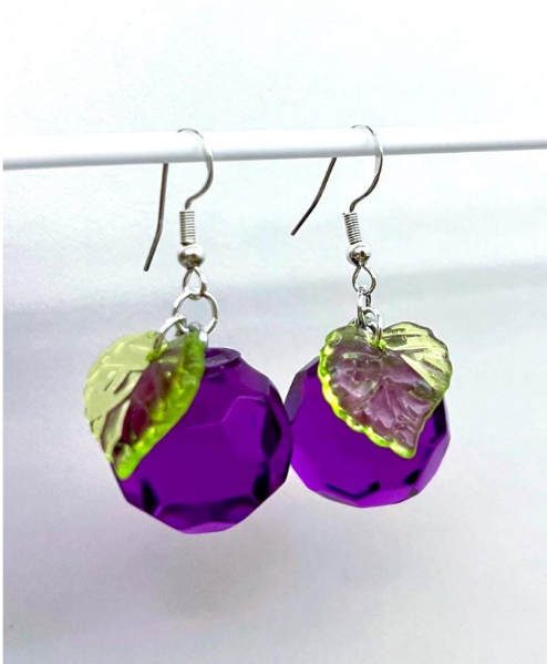 Purple grape inspired earrings with a leaf attached on a white background